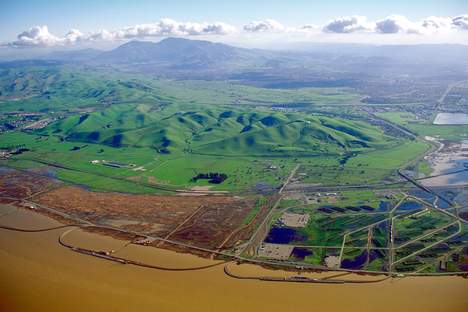 Archival aerial view toward Mount Diablo from Concord, with green hills and waterfront in the foreground.